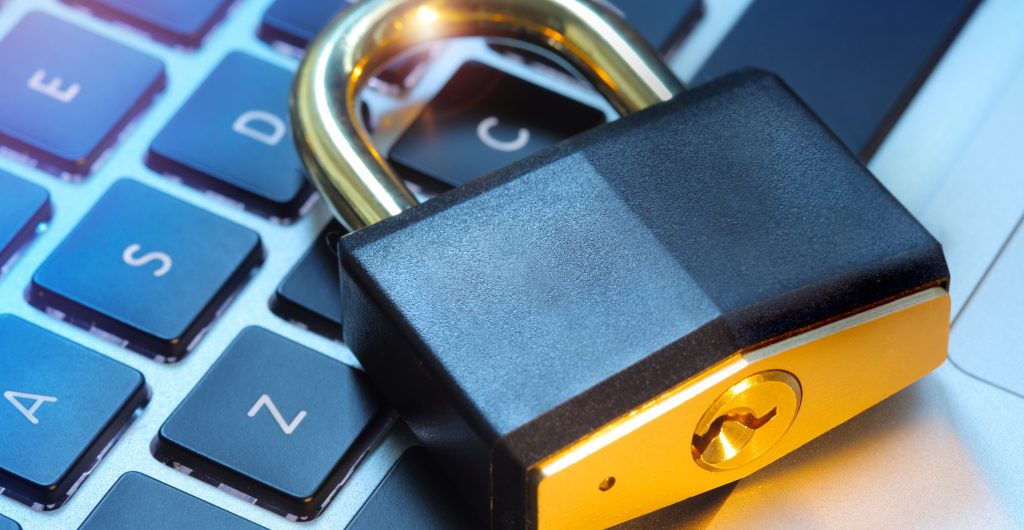 Padlock laying on top of a computer keyboard.