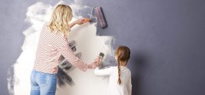 Mother and daughter painting a room blue