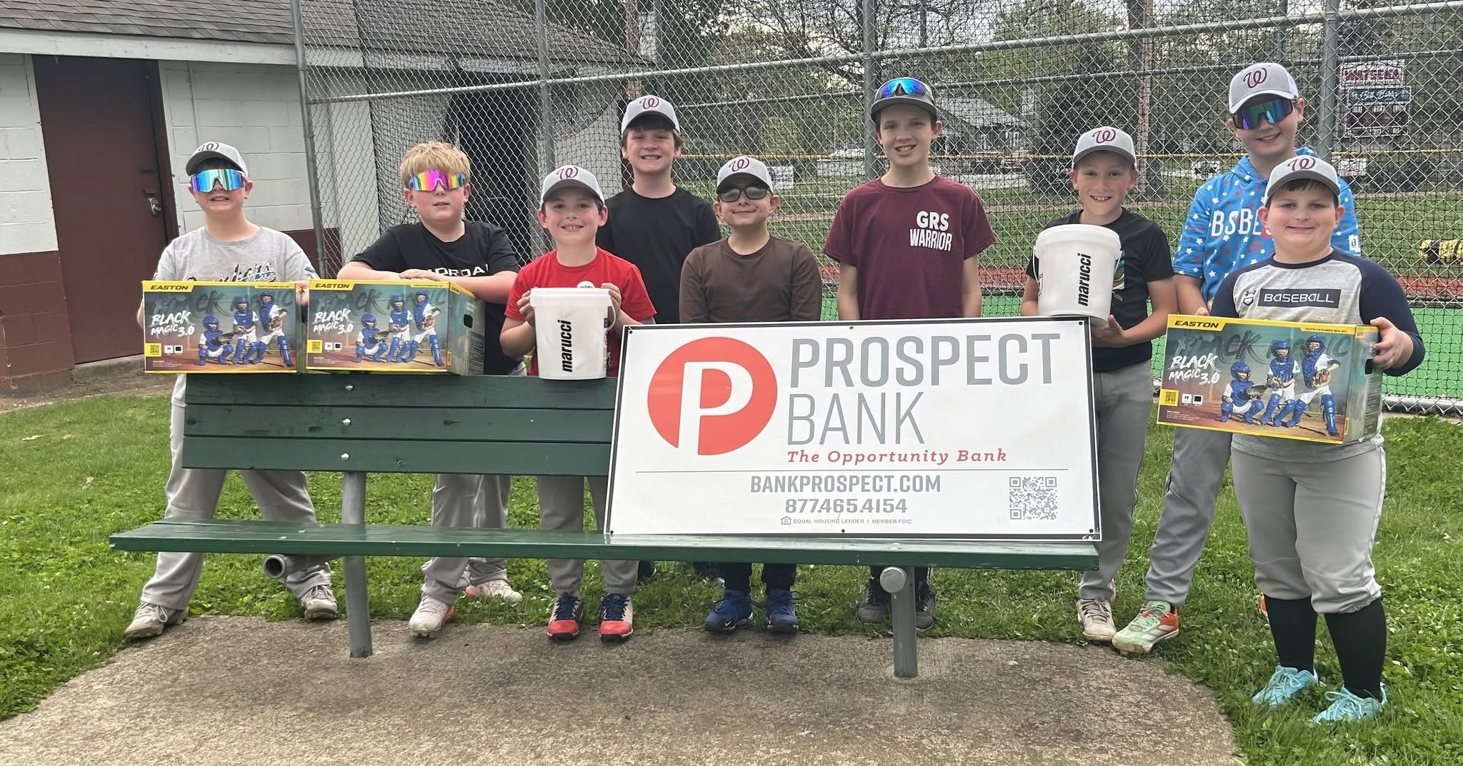Little League Baseball Team poses with a Prospect Bank sign